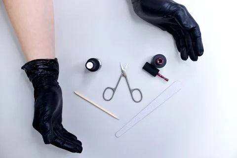 Top view of hands in black gloves, manicure scissors, manicure tools, nail ge Stock Photos