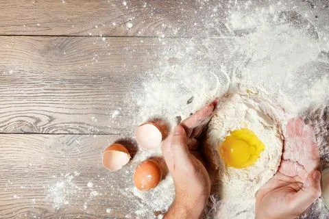 The top view, the hands of the cook, the egg knocked into the flour, a glass  Foto stock