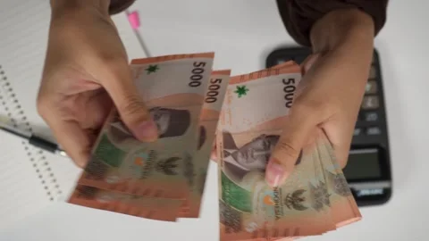 Top view hands counting money Indonesian rupiah with calculator 库存影片 276400962