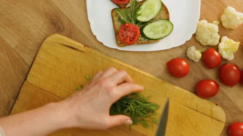 Top view hands cuts dill making vegan sandwich Stock Footage