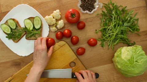Top view hands cuts tomato making vegan sandwich Stock Footage 131161457