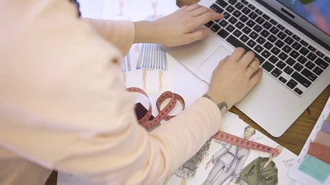 Top view of the hands of a female tailor who works on a laptop. Video stock 87324315