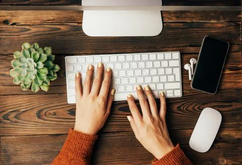 Top view on hands with manicure on a computer keyboard on a work surface. Stock Photos