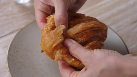 Top view of hands picking freshly baked crusty buttery croissant up, breaking in Stock Footage 146048307