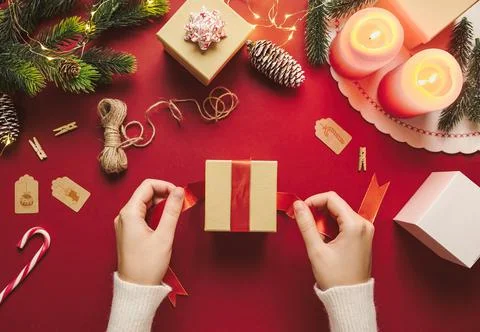 Top view of hands preparing and wrapping Christmas gift box. Merry Xmas rusti Stock Photos