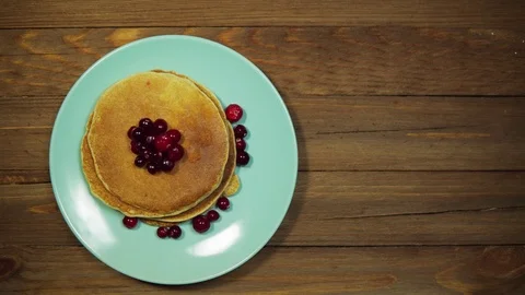 Top view hands put plate with pancakes and berries on wooden table, dolly shot. Stock Footage 102215089