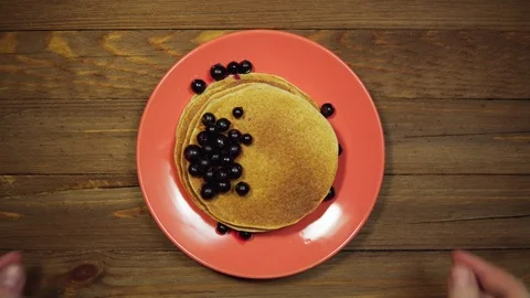 Top view hands put plate with pancakes and berries on wooden table, dolly shot. Stock Footage 102215253