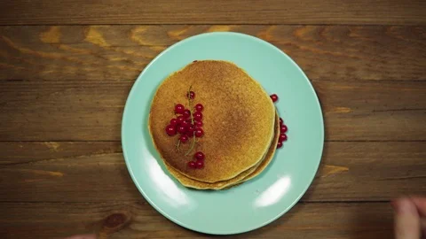 Top view hands put plate with pancakes and berries on wooden table, dolly shot. Stock Footage 102215393