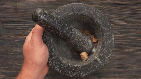 Top view of hands putting sea salt and brown sugar into the grey stone mortar Stock Footage 169813643