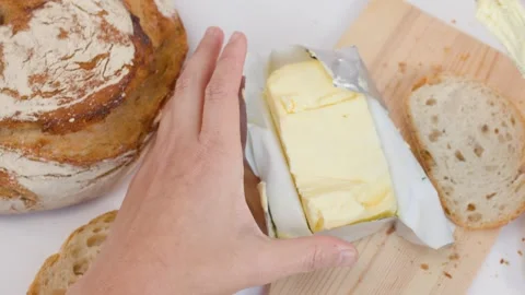 Top View of Hands Slicing Butter and Spreading on Sourdough Bread Stockbeeldmateriaal 337519459