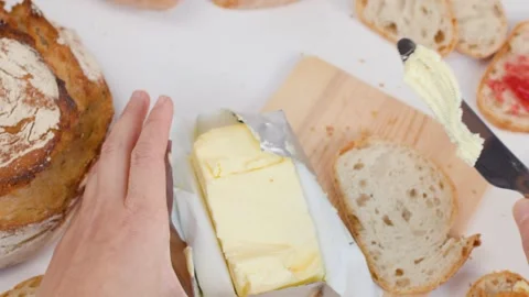 Top View of Hands Slicing Butter and Spreading on Bread Stockbeeldmateriaal 337748359