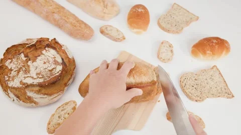 Top View of Hands Slicing Fresh Sourdough Bread on Wooden Board Stockbeeldmateriaal 337767713