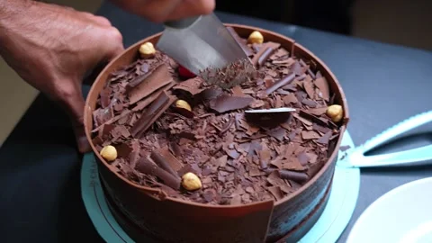 Top View of Hands Slicing Luxurious Chocolate Cake with Nuts and Raspberry Stock Footage 313281330