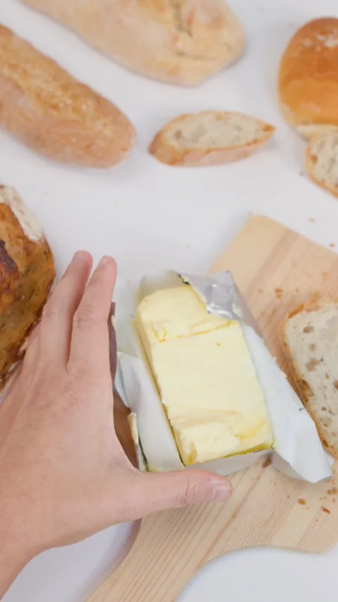 Top View of Hands Spreading Butter on Sourdough Bread Slice Stockbeeldmateriaal 337281492