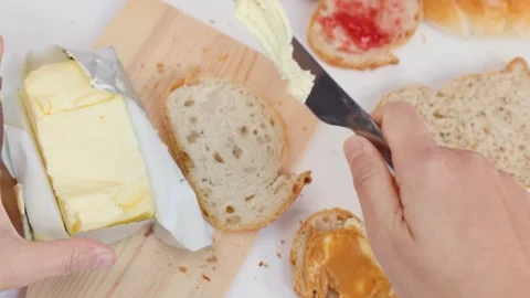 Top View of Hands Spreading Butter on Sourdough Bread Stockbeeldmateriaal 337917947
