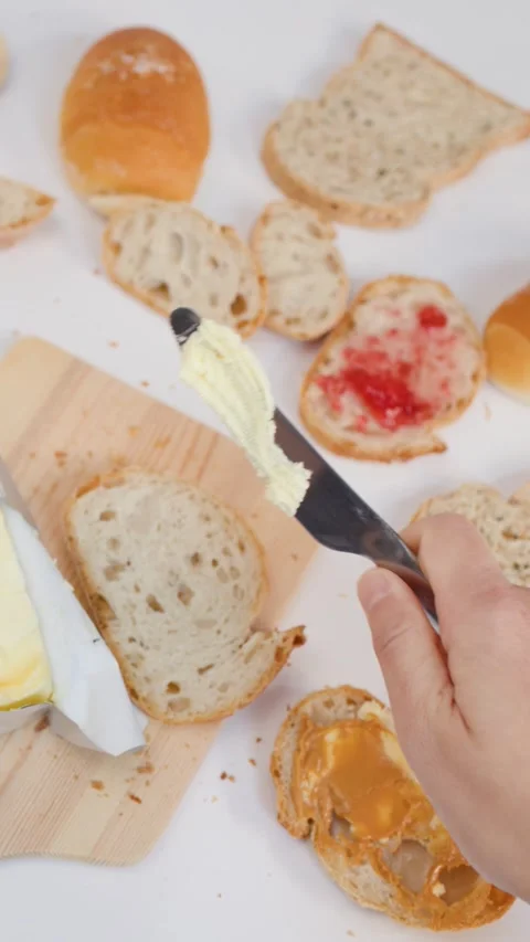 Top View of Hands Spreading Fresh Butter on Sourdough Bread Stockbeeldmateriaal 337690901
