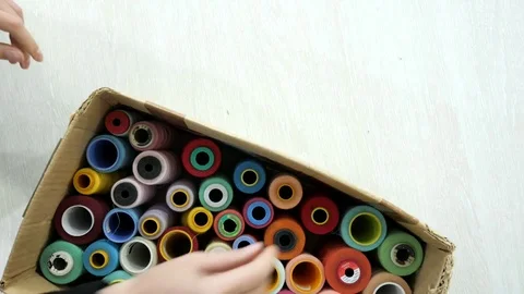 Top view. Hands takes multi-colored spolls from the box. Stock Footage