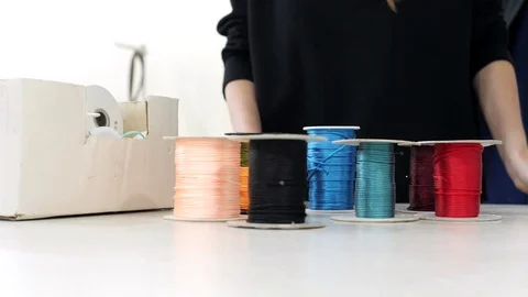 Top view. Hands takes multi-colored spolls from the table. Stock Footage