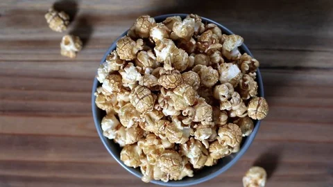 Top view of hands taking sweet caramel popcorn Stock Footage 75226775
