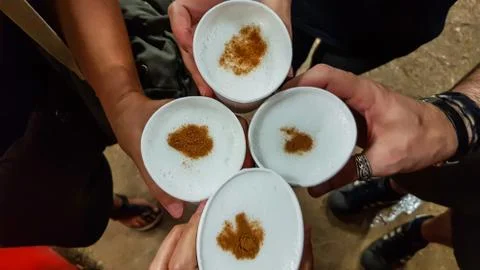 Top view of hands toasting with typical Peruvian drink: Pisco Sour Stock Photos
