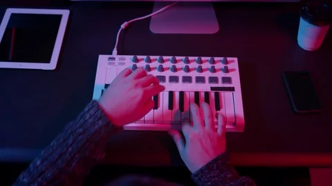 Top view of hands using midi keyboard in home studio with neon lights 스톡 동영상 142838723