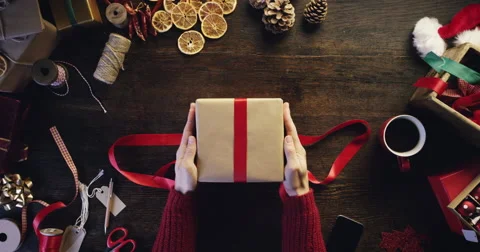 Top view hands wrapping christmas presents at wooden desk from above - Red Epic Stock Footage
