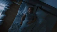 Top View Of Handsome Young Man Sleeping Cozily On A Bed In His Bedroom At Night. Stock Footage