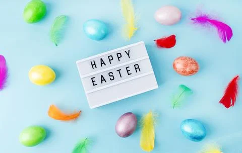 Top view Happy Easter light box decorated with bright colored eggs and feathe Stockfoto's