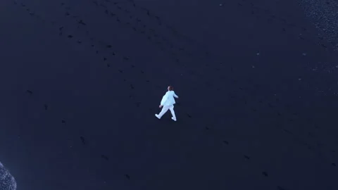 Top view of happy man in white suit enjoying the beauty of Reynisfjara beach Stock Footage 258126676