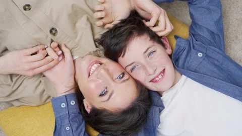 Top view Happy mother and son laughing playing having fun lying on floor at home Stock Footage 238632945