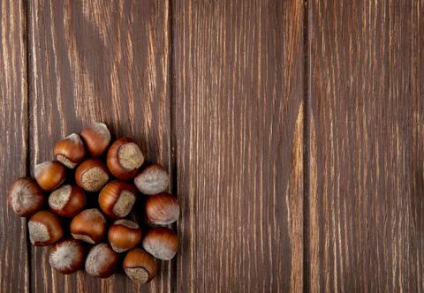 Top view of hazelnuts in shell scattered on wooden background with copy space Stock Photos