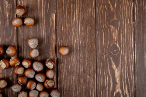 Top view of hazelnuts in shell scattered on wooden background with copy space Stock Photos