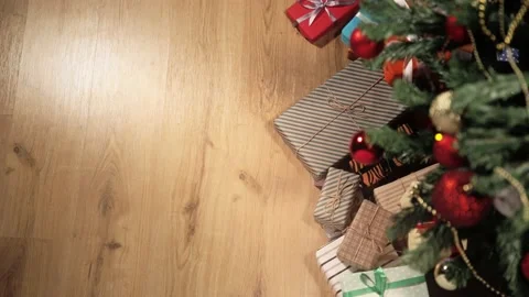 Top view. He puts big gift wrapped in striped brown paper tied with rope and red Stock Footage 163451415