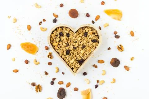 Top view of a heart shaped bow full of crunchy granola. Healthy eating concept Stock Photos