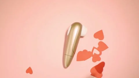 Top view hearts falling on clitoral vibrator. Slow motion Stock Footage
