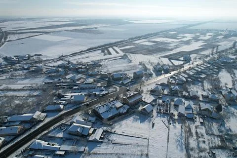 Top view of the highway and parallel railway. Snow-covered fields and houses. Stock Photos