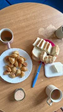 Top view of home dining table with plate of fried dumplings, sliced bread, 库存照片