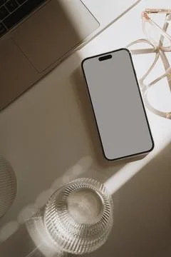 Top view home office workspace. Mobile phone with blank white screen, laptop  Stock Photos