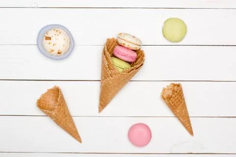 Top view of homemade macarons pattern with waffle cones, sweets background Foto stock