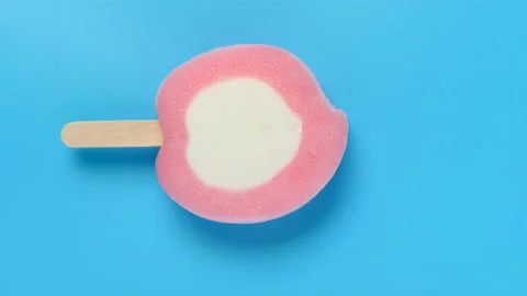 Top view honey peach shape and flavor popsicle melting on a blue background Stock Footage 135950429