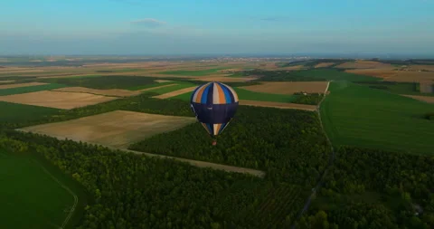 Top view of hot air balloon flying above green landscape, US. Drone shot balloon Video stock 256978408