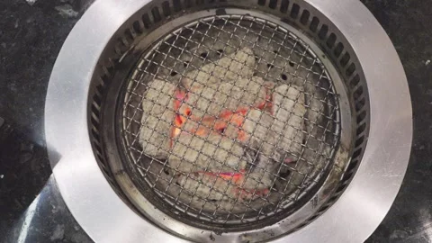 Top view of hot charcoal glowing under a wire mesh grid in a circular BBQ g.. 스톡 동영상 333978859