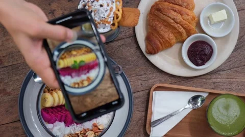 Top view of human hand shooting a video of brunch dishes in modern cafe for Stock Footage 166455202