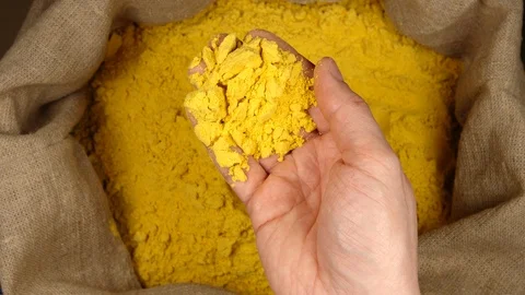 TOP VIEW: Human hand takes a handful of a turmeric (curcuma) powder in a sac Stock Footage 90442525