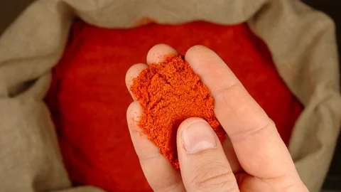 TOP VIEW: Human hand takes a pinch of red pepper from a sac Stock Footage 121942473
