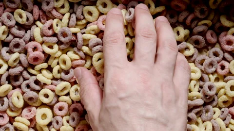 TOP VIEW: Human hand takes a colourful corn flakes Stock Footage 202066430