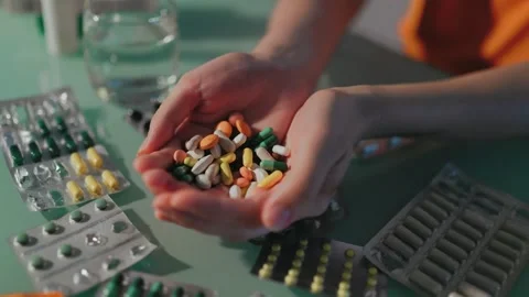 Top view of human hands holding white pharmaceutical capsules over desk. Stock Footage 339205203