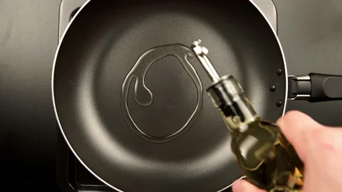 TOP VIEW: Human hands pouring olive oil on the frying pan Видео 141978370