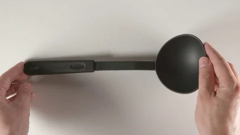 TOP VIEW: Human hands puts a black plastic scoop on a white table Stock Footage 74730400