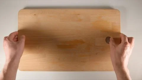 TOP VIEW: Human hands puts big cutting board on a white table Stock Photos